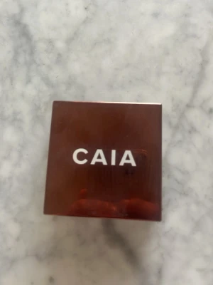 CAIA bronzer Venice - Säljer en bronzer från CAIA i nyansen Venice. Kommer i en snygg, fyrkantig brun kompaktförpackning med spegel. Pudret har en varm, solkysst ton som ger huden glow och definition. Perfekt för att framhäva ansiktets konturer.