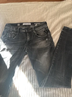 Grå/svarta Replay jeans med slitningar - Svart/gråa slim fit jeans från Replay(anbass) med slitningar. (W28 L32) köpt för några månader sedan men knappast använd 