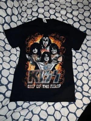 KISS End of the Road tour t-shirt - Säljer en svart KISS End of the Road tour t-shirt med stort tryck av bandmedlemmarna och eld på framsidan. Baksidan har texten Sölvesborg, världskarta i eld och 'Shout it out loud!'. Perfekt för dig som älskar rock och vill sticka ut.