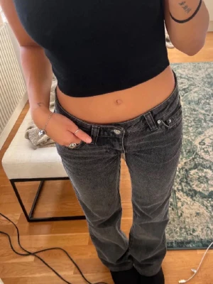 Gråa Gina Tricot Y2 K Lågmidjade Jeans - Bootcut low waist grå jeans från Gina Tricot med snygga broderade bakfickor. Storlek 164 och passar S. 