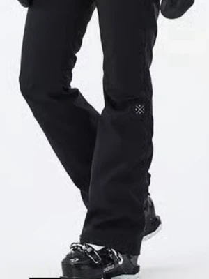 Svarta täckbyxor från Dope Snow - Säljer ett par svarta täckbyxor från Dope Snow med diskret logga på benet. Byxorna har utsvängd passform och är tillverkade i slitstarkt, vattenavvisande material som passar perfekt för vinterns alla äventyr i backen. Modell tigress, har för mig att dessa är något små i strl.