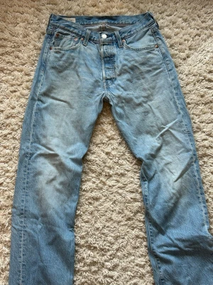 Ljusblå Levi’s 501 - Säljer dessa ljusblå Levi’s 501 i storlek  W29 L30  Bra skick, enda slitaget är byxbenen som blivit lite fransiga som syns i sista bilden. Priset är ej hugget i sten  Skriv gärna vid frågor!