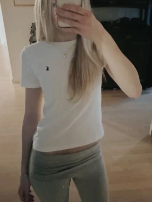 Vit t-shirt från Ralph Lauren - Säljer en klassisk vit t-shirt från Ralph Lauren med den ikoniska lilla loggan broderad på bröstet. T-shirten har rund halsringning och korta ärmar. Perfekt basplagg som passar till allt och är gjord i mjuk bomull.