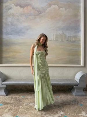 Ljusgrön långklänning med mönster - Säljer en elegant ljusgrön långklänning med spetsdetaljer på överdelen. Aldrig använd, endast testad med lappen kvar!☺️