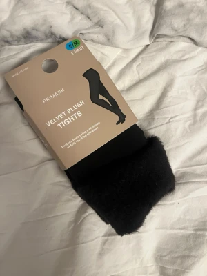 Svarta Velvet Plush tights Primark - Mysiga svarta Velvet Plush tights från Prim clock, storlek S/M. Tightsen är extra mjuka sopch har en sopbar plyschinsida. Tillverkade med minstr 50% återvunnen polyester. Perfekta sopm basplagg till höst och vinter som håller dig varm.