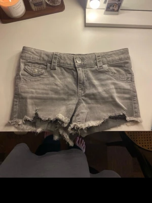 Grå jeansshorts med fransig kant - Lågmidjade jeansshorts använt endast en gång som nya, storlek 158 men passar mig som är 166 och vanligtvis bär S/xs i shorts 