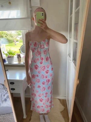 Turkos långklänning med rosa rosor Gina tricot  - Jättefin långklänning från Gina tricot. ALDRIG ANVÄND och har lappen kvar😍 bara att skriva om du undrar nåt eller vill ha fler bilder eller mått så löser jag det🌸pris kan diskuteras🥰