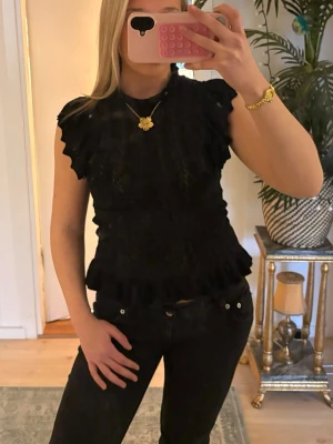 Svart spetsblus med volangdetaljer - Säljer en svart blus med spets detaljer 