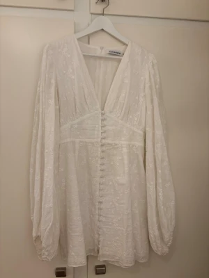 Vit långärmad klänning adoore - Jätte fin klänning från adoore, perfekt till studenten. Använd 2 gånger så den är nästan i nyskick, storlek 42 men skulle säga att den är ganska liten i storlek så passar en storlek 40