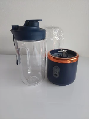 Bärbar blå mixer med kopparring - Snygg och smidig bärbar mixer i blått med kopparfärgad ring. Mixern har en genomskinlig plastbehållare och ett lock med drickpip. Perfekt för smoothies eller shakes på språng. Laddas enkelt via USB och har vassa blad i rostfritt stål.