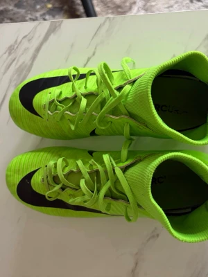 Neongröna Nike Mercurial fotbollsskor - Säljer ett par neongröna Nike Mercurial fotbollsskor som är pros. Nostalgi skor som hämtar tillbaka många minnen. Konstgrässkor.