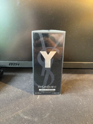 Yves Saint Laurent Y Eau de Parfum - Y Eau de Parfum från Yves Saint Laurent i en elegant svart förpackning med stor silverfärgad Y-logga. Flaskan rymmer 100 ml och har en modern, stilren design som känns lyxig och trendig. Perfekt för dig som gillar exklusiva dofter och snygg förpackning.