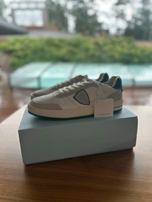 Oanvända Philippe Model 43 Herrskor Vit/Grön - Snygga sneakers från Philippe Model i vitt läder och mocka med gröna detaljer, perfekta under sommaren. Skorna har aldrig haft en fot i sig, aldrig klivit ett steg, sprillans nya som ni kan se på den andra bilden. De är självklart äkta och kvitto ingår. Antingen kan ni hämta dem i sollentuna eller så kan jag frakta de med köparskydd. Storleken är 43, de är större i storleken. nypris ligger på 3000kr, mitt pris endast 1399kr.