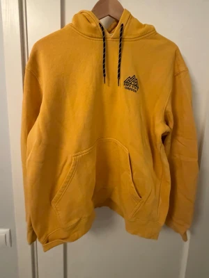 Gul hoodie hm - Gul hoodie från hm med litet tryck på framsidan