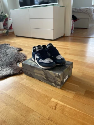 Marinblå och vita sneakers från Valentino - Snygga sneakers från Valentino i marinblått och vitt med meshdetaljer och mocka på ovandelen. Skorna har en klassisk låg siluett, vita sulor och svarta skosnören. Perfekta för dig som vill ha en stilren och trendig look. Vill ni ha mer bilder är det bara att fråga😄