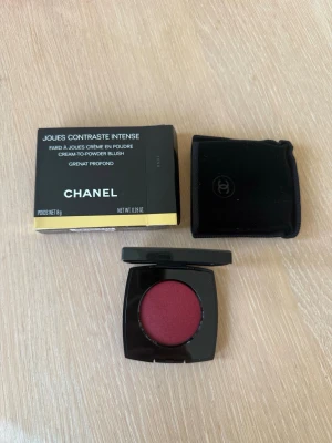 Chanel rouge Grenat Profond - Lyxigt rouge från Chanel i nyansen Grenat Profond. Färgen är en djup vinröd med matt finish. Kommer i en elegant svart dosa med spegel och tillhörande sammetsfodral. Pudret har en kräm-till-puder-formula som ger ett naturligt resultat. Helt oanvänt.