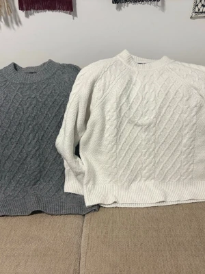 Grå stickad tröja från 157 - Säljer en grå stickad tröja från 157 med klassiskt flätmönster och ribbade muddar vid hals, ärmslut och nederkant. Tröjan har rund halsringning och är perfekt för kyliga dagar. Materialet känns mjukt och mysigt. 2 för 120kr 1 för 70kr.