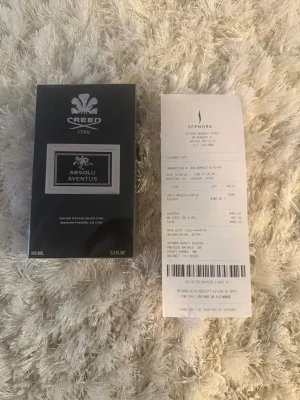 Creed Absolu Aventus 100ml parfym - Lyxig parfym från Creed, modellen Absolu Aventus. Flaskan rymmer 100 ml och kommer i en elegant svart förpackning med silverdetaljer och tydlig logotyp. En exklusiv doft som utstrålar klass och stil, perfekt för dig som vill sticka ut.