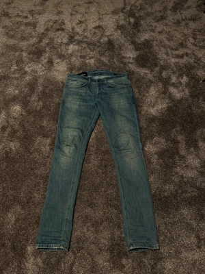 Dondup Jeans STL 29 - Dondup jeans med klassisk femficksdesign och diskreta slitningar på framsidan. Jeansen har normal midja och raka ben. Perfekta för en avslappnad och trendig look. STL 29 sitter Fits 32