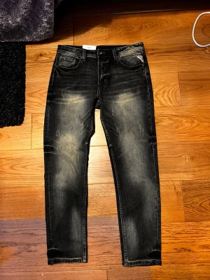 Blåa jeans från Indigo Man - Snygga blåa jeans från Indigo Man med slitna detaljer och tvättad look. Klassisk femficksmodell med raka ben och normal midja. Jeansen har en cool faded effekt och är tillverkade i denim.