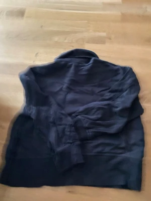 Svart hoodie från 157 - En svart hoodie från 157 i storlek M. Klassisk modell med huva och ribbade muddar vid ärmslut och nederkant. Perfekt för en avslappnad och enkel stil. Tillverkad i mjukt material som känns skönt mot huden.