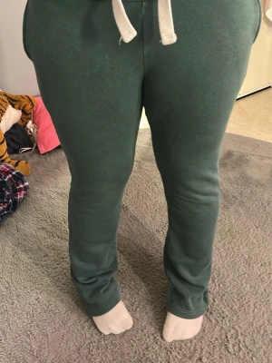 Gröna mjukisbyxor och tröja från gina  - Grönt mjukis set med mjukis byxor och zip hoodie. Byxorna är i storlek s och zip hoodien är i storlek m