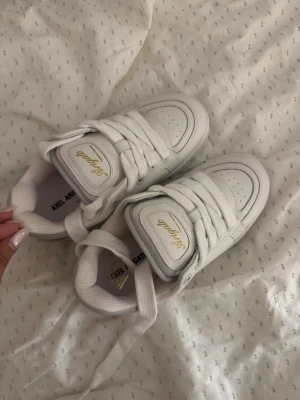 Vita sneakers Axel Arigato - Säljer ett par vita sneakers från Axel Arigato med gulddetaljer och logga på sidan. De är helt oanvända och kommer ej till användning. Har tyvärr slängt lådan till skorna. hör av er vid fler frågor💗