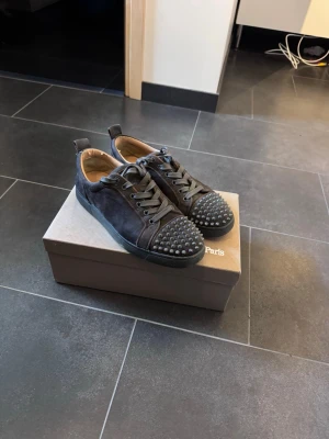 Christian Louboutin  - Svart/grå skor  i mocka från Christian Louboutin. Storlek 42.