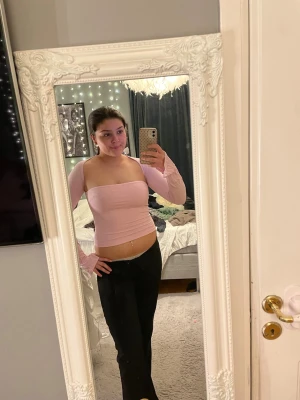 Ljusrosa offshoulder topp - Trendig ljusrosa offshoulder topp med långa ärmar och tight passform. Toppen är croppad och har en stilren, enkel design utan synliga detaljer. 