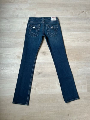 Blåa True Religion Bootcut Billy Jeans W27 - Fina True Religion Jeans i Blå färg. Jeansen är i mycket bra skick och sparsamt använda. |  Äkta som allt annat jag säljer! ✅ |  Storlek: W27 | Skick: Mycket Bra Skick/Nyskick | Färg: Blå | Märke: True Religion | Modell: Jeans |  Hör gärna av dig vid frågor så svarar jag så fort jag kan! 😁|  