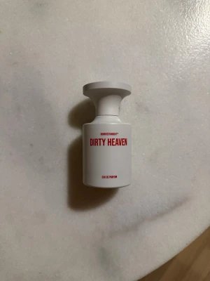 Dirty Heaven parfym från Borntostandout Sample 70kr/ml - Dirty Heaven från Borntostandout är en Eau de Parfum i en stilren vit flaska med röd text. Doften har noter av tonkaböna, vanilj, saffran, amber, ambroxan, vita blommor, jasmin och neroli. Flaskan har en modern, cylindrisk form med bred kork. 70kr/ml