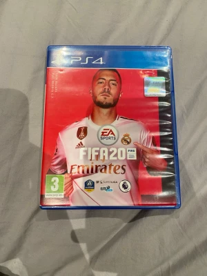 FIFA 20 till PS4 - Säljer FIFA 20 till PlayStation 4. Spelet kommer i ett blått plastfodral med röd och vit omslagsdesign och inkluderar skiva, manual och bonusmaterial. Perfekt för dig som gillar fotbollsspel och vill bygga ditt eget drömlag i Ultimate Team.
