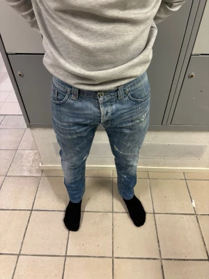 Dondup Jeans - Jar - Säljer dessa snygga Dondup Jeand i modellen ”Jar”. Midjestorleken står inte men måtten är - Midja 44,5cm - ytterben 90cm - innerben 66cm. Jeansen är äkta och alla slitningar är från fabrik. Skicket är i 7/10, som ni kan se på sista bilden så är tvättlappen lite skadad men det är den äkta defekten. Skriv gärna vid funderingar och ha koll på era storlekar innan ni köper! Just denna jeans modellen har en bred midja men korta ben. Mvh!