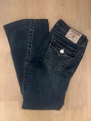 True Religion mörkblå bootcut jeans - Säljer ett par mörkblå bootcut jeans från True Religion. Uppsydda för o passa mig som är 158