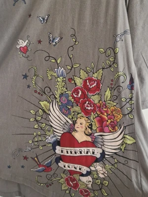 cool tröja - Unik militärgrön topp från KappAhl med stort fint tryck och trekvartsärm. Helt nytt skick, endast provat. Storleken är 44/46.