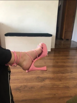 Rosa platåklackar med snörning - Säljer ett par trendiga rosa platåsandaler med höga klackar och tunna remmar som snörs runt ankeln. Perfekta för dig som vill sticka ut med färg och höjd.