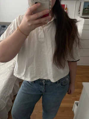 Kappa White Polo Shirt Cropped Fit - Clean and versatile white polo shirt from Kappa with a subtle black logo on the chest. Features a slightly cropped / boxy fit that gives it a relaxed, modern silhouette – perfect for everyday wear. Brand: Kappa Color: White with black details Fit: Cropped / boxy / slightly oversized Material: Soft cotton (classic polo texture) Condition: Good vintage condition (small signs of wear, see pictures) 📏 Fits like: S–L depending on desired fit Perfect basic piece that goes with everything