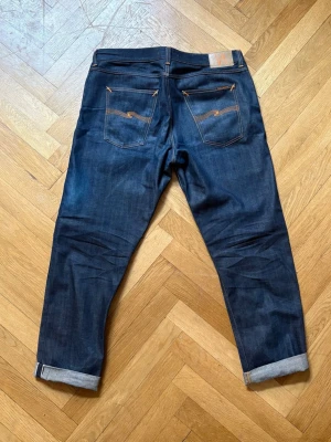 Selvedge Nudie jeans  - Ett par feta selvedge nudies, nästan helt nya. Inga skador på jeansen. Midja:48cm Längd:110cm. Modellen är steady eddie II.