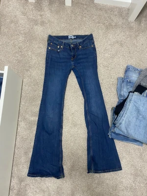 Blå bootcut jeans från lager  stroken M - Säljer ett par klassiska blå bootcut jeans från lager Jensen har normal midja och utsvängda ben. Tillverkade i slitstark denim med snygga kontrastsömmar. Perfekta för en avslappnad och trendig look. Lite hål vid röven men jag har sytt