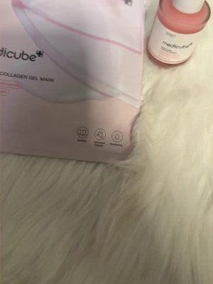 Medicube PDRN Pink Collagen Kit - Säljer ett kit från Medicube med PDRN Pink Collagen Gel Mask och ett matchande serum. Båda produkterna har rosa och vita förpackningar och innehåller ingredienser som niacinamid och hydrolyserat kollagen för återfuktande och lugnande effekt.