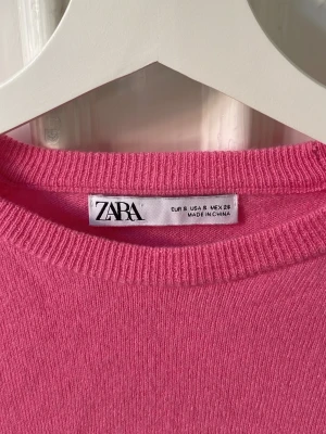 Rosa stickad tröja från Zara - En enkel och snygg rosa stickad tröja med ribbade muddar vid hals, ärmslut och nederkant. På bilderna är den väldigt skrynklig, därför ser den ut som den gör (inget fel på den). Skriv DM för fler bilder. 
