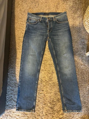Solid Ollie Wild jeans från Nudie Jeans - Säljer ett par klassiska blå jeans från Nudie Jeans med raka ben och fem fickor. Också tillkommer gratis lagning för jeansen livet-ut, Har aldrig haft på mig de på grund av att dom är för stora, sitter som W32, L32. Kvitto medkommer.              Nypris: 1800kr