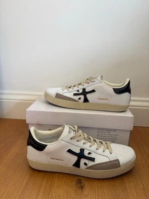 Vita Premiata sneakers med svart detalj - Hej 👋 jag säljer mina helt nya premiata sneakers som endast är använda en gång. De har inga defekter och Box ingår !