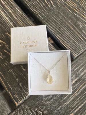 Caroline Svedbom halsband  - Super fint halsband från Caroline Svedbom, mini drop necklace i färgen linne ignite. Endast använt 1 gång så i nyskick!