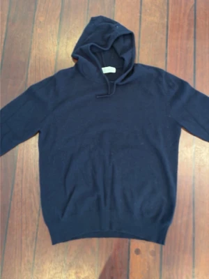 Mörkblå kasmir hoodie Sayless - Mysig mörkblå hoodie från Sayless i mjuk kasmir. Klassisk modell med huva och dragsko, ribbade muddar vid ärmslut och nederkant. Perfekt för dig som gillar stilrena och bekväma plagg med exklusiv känsla. (Storlek S men passar som XS)