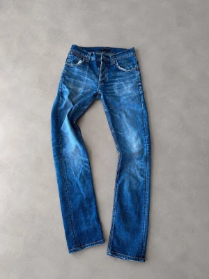 Nudie jeans i modellen grim tim - Jag saljer ett par nudie jeans i modellen grim tim Storlek 29/32 Riktigt fina fades och naturliga slitningar Langd: 103 cm Midja: 35 cm Dem har ett hål i den högra fickan (se på sista bilden) Priset är inte hugget i sten så det är bara att buda!
