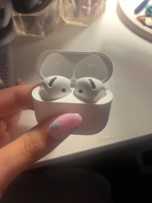 Apple AirPods 4 med laddningsetui - Säljer ett par vita Apple AirPods 4 med trådlöst laddningsetui. Snygg och smidig design i plast, perfekt för musik, poddar och samtal. Garanti fram till 2027 och är i airpodsen har inga defekter utom lite smuts i laddningetuitet men självaste airpodsen fungerar som nytt!🥰