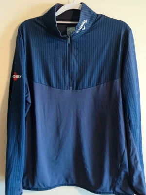 Callaway golftröja - Mörkblå långärmad 1/4 zip sporttröja från Callaway. Perfekt för golf eller annan träning. Den är gjord väldigt lent och skönt material som inte ska störa swingens process!                 Endast använd ett fåtal gånger!! 