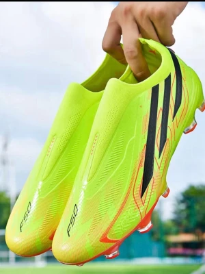 Neongula fotbollsskor F50 - Säljer ett par neongula fotbollsskor med svarta detaljer och F50-tryck på tån. Skorna har en strömlinjeformad design och röda inslag vid sulan. Perfekta för dig som vill sticka ut på planen och få bra grepp på gräset.