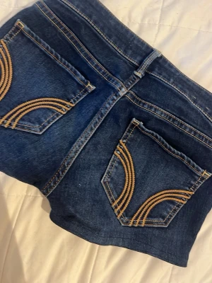 Hollister shorts  - Snygga mörkblå jeansshorts från Hollister. Klassisk femficksmodell med knapp och dragkedja framtill. Perfekta för varma dagar och enkel att matcha med olika toppar. Lågmidjade!